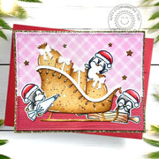 A handmade Christmas card featuring a holiday gingerbread house-inspired colored sleigh with gifts & penguins in Santa hats.