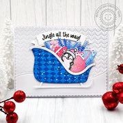 Penguin in a sleigh with gifts and trees; pink & blue handmade holiday Christmas card with a "Jingle all the way" greeting.