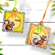 Two handmade hanging "thank you" gift tags with gold-glitter scalloped-edge borders, ribbon ties, & squirrel illustrations.