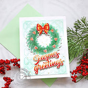 Christmas card featuring a pine bough holiday wreath decorated with berries, a red bow, and a "season's greetings" sentiment.