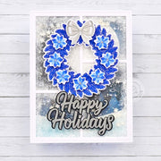 Stamped silver, white, and blue winter holiday wreath on a frosty window Christmas shaker card with happy holidays sentiment.