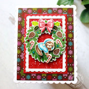 Holiday Card featuring a sloth hanging from a Christmas wreath, framed with a scalloped mat on a snowflake-print background.