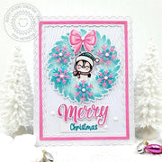 Pink & aqua scalloped holiday card featuring a snowflake wreath with a penguin in the center & a "Merry Christmas" greeting.